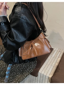 Vista dettagliata della borsa a tracolla in pelle marrone lucida con etichetta moda