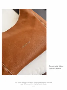 Detail of premium brown leather texture with white stitching and embossed logo