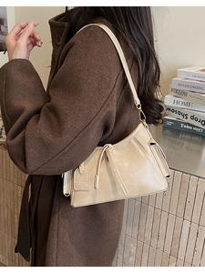 Dettaglio della borsa sottobraccio vintage color crema con coulisse e targhetta