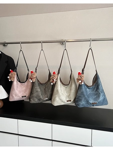 Close-up of four marble-textured bucket bags in assorted colors with plush bear charms