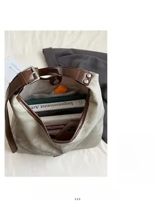 Detail view of olive canvas bucket bag with brown leather straps and large capacity