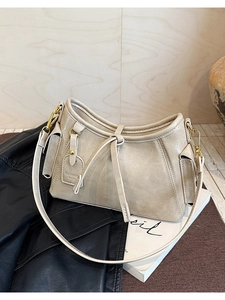 Dettaglio borsa beige in ecopelle con tasca laterale e fibbie in metallo dorato
