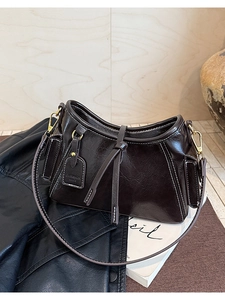 Dettaglio delle cuciture a contrasto e della pelle lucida su una borsa a secchiello vintage