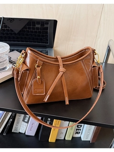 Dettaglio borsa a tracolla marrone vintage con pelle martellata e finiture dorate