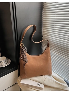 Detailed close-up of a brown matte leather Hobo bag with stylish braided rope decoration