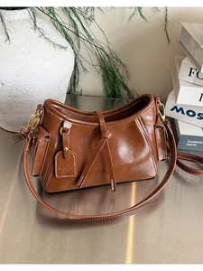 Dettagli della borsa a secchiello marrone vintage in pelle cerata lucida e fibbie d'oro