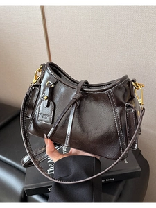 Dettaglio della pelle lucida cerata e delle cuciture bianche su questa borsa vintage