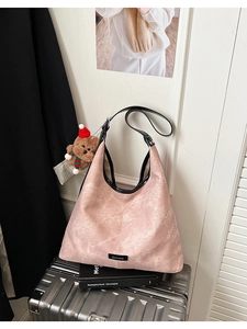Pink marble pattern hobo bag on a silver suitcase with a cute teddy bear charm
