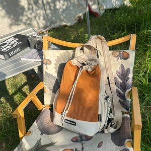 Zaino casual per esterni con design patchwork arancione su sedia da campeggio