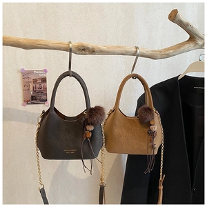 Gros plan de sacs seaux mats avec chaînes métalliques et glands décoratifs en fourrure