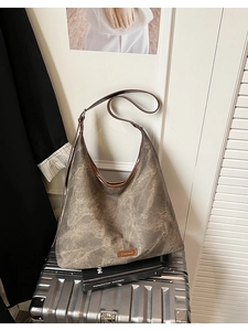 Detailed close-up of retro canvas tote bag with brown leather trim and embossed brand tag