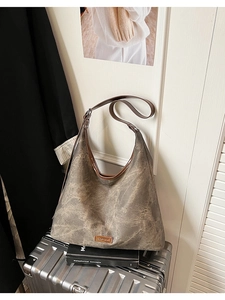 Close-up of vintage taupe marble texture tote bag with brown leather trim on luggage
