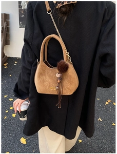 Sac seau en daim marron avec bandoulière dorée et pompon décoratif en fourrure