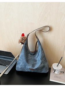 Detail of vintage navy blue tote bag with retro texture and a cute teddy bear charm