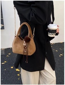 Sac seau givré marron avec chaîne dorée et breloque en peluche, style urbain hivernal