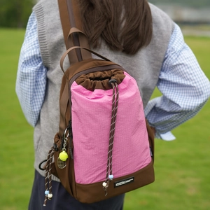 Dettaglio dello zaino con coulisse bicolore rosa e marrone e ciondolo da tennis