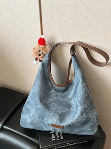 Vintage blue canvas bucket bag with brown leather trim and festive plush puppy pendant