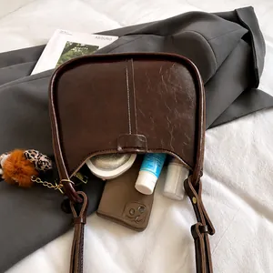 Innenraum-Detail der dunkelbraunen Vintage-Beuteltasche mit Leoparden-Anhänger