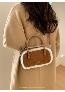Braune Lammfell-Tasche an einem Modell, das einen herbstlichen Wollmantel trägt