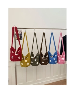 Détail de sacs seaux en peluche colorés avec broderies florales et boutons en bois naturel