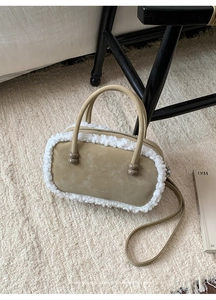 Detailansicht der Retro-Bowlingtasche mit Lammfellbesatz und geprägtem FASHION-Schriftzug