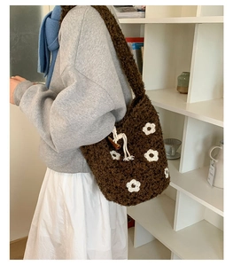 Détail d'un sac seau en peluche marron avec motifs de fleurs et fermoir en bois