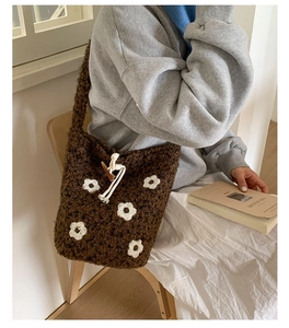 Détail du sac seau en peluche marron avec broderie florale et fermeture à bascule