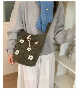 Détail du sac seau en crochet vert foncé avec fleurs 3D et fermeture par cordon