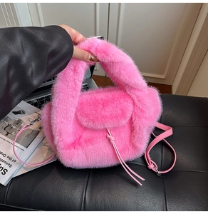 Detail einer rosa Plüsch-Handtasche mit stilvollem Knotendetail und weicher Textur