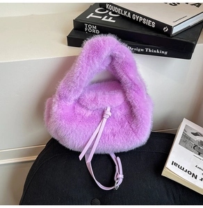 Nahaufnahme der lila Plüsch-Handtasche mit verknotetem Lederriemen auf schwarzem Stuhl
