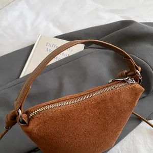 Λεπτομέρεια καφέ σουέτ τσάντας bucket με γεωμετρικό σχέδιο και ασημί φερμουάρ
