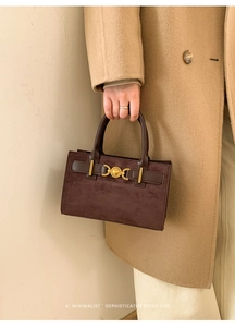 Primer plano de bolso retro marrón con detalle de hebilla metálica dorada de corazón