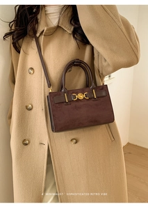 Detalle de un bolso vintage de ante marrón combinado con un abrigo color camel