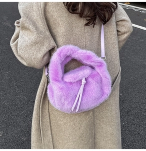 Detailansicht der lila Kunstfell Handtasche mit Knotengriff und Leder-Schultergurt