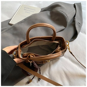 Detailed top view of brown pebble leather bucket bag with zippered inner compartment