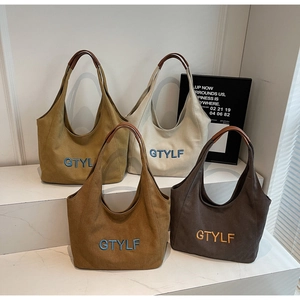 Detailed view of four canvas tote bags in mustard, cream, brown, and dark coffee colors