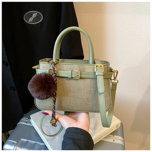 Détail du sac seau à texture tissée avec breloque en peluche et perles de lettres