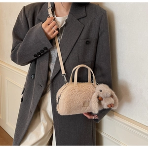 Detail der beige Plüsch-Tasche mit weichem Lammwolle-Effekt und niedlichem Hasenanhänger