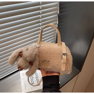 Details der flauschigen beigen Beuteltasche mit Leder-Patch und süßem Hasen-Anhänger