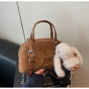 Detail der karamellfarbenen Plüschtasche mit Hasenanhänger und Leder-Tragegriffen