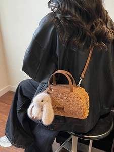 Braune Plüsch Boston Tasche mit süßem Kaninchen-Anhänger am Model getragen
