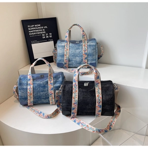 Detail of denim canvas Boston bags with floral straps and leather logo patches