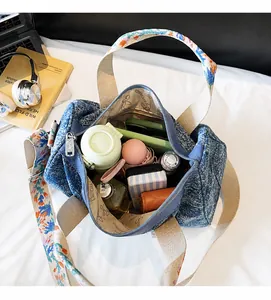 Blue denim barrel bag interior showing large capacity for umbrella, phone, and daily items
