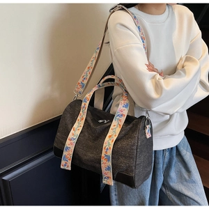 Detail showing the colorful floral woven shoulder strap on a grey canvas tote bag