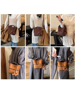 Detail view of suede bucket bag in dark brown and caramel with dachshund charm accessory