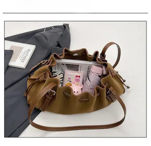 Detailed capacity view of a brown leather drawstring tote bag filled with daily essentials
