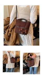 Vue détaillée du sac seau en daim marron avec surpiqûres blanches et charme de chien