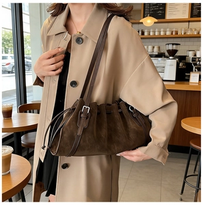 Close-up of a dark brown pleated tote bag featuring drawstring detail and soft matte texture
