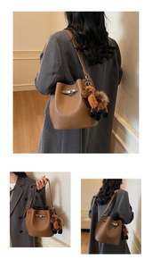 Detailed view of brown litchi grain leather bucket bag with silver lock and horse charm