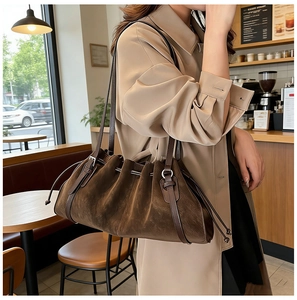Detail of vintage brown suede tote bag with drawstring texture and silver metal rings